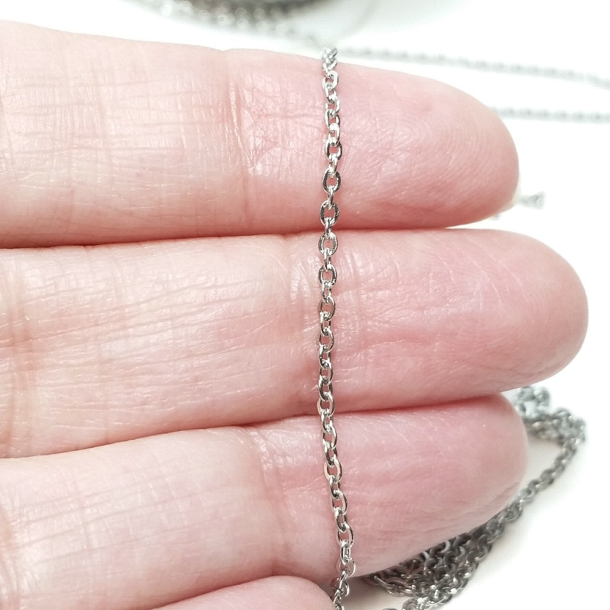 Chain draped over fingers for size comparasion